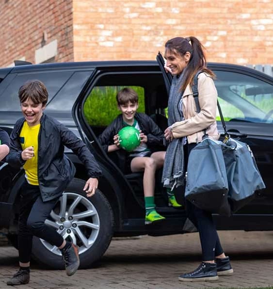 a group of children running out of a car
