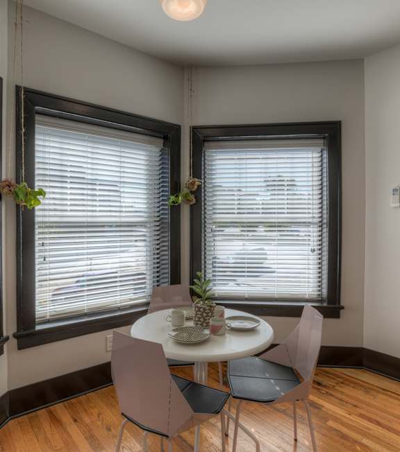 A dining room with a table and chairs.