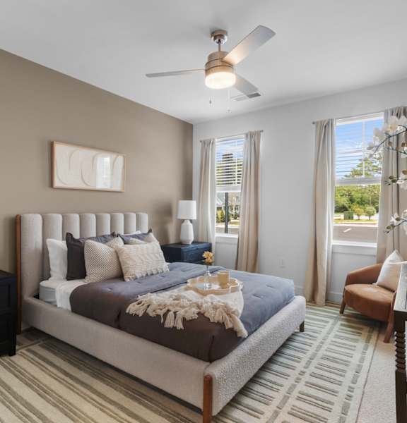 A bedroom with a large bed and a ceiling fan.