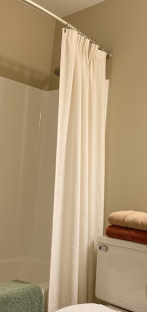A bathroom with a white sink, toilet, and shower curtain.