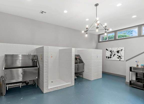 A clean, empty industrial kitchen with stainless steel appliances and a yellow mop. at Northpoint Apartments, Washington, 98407