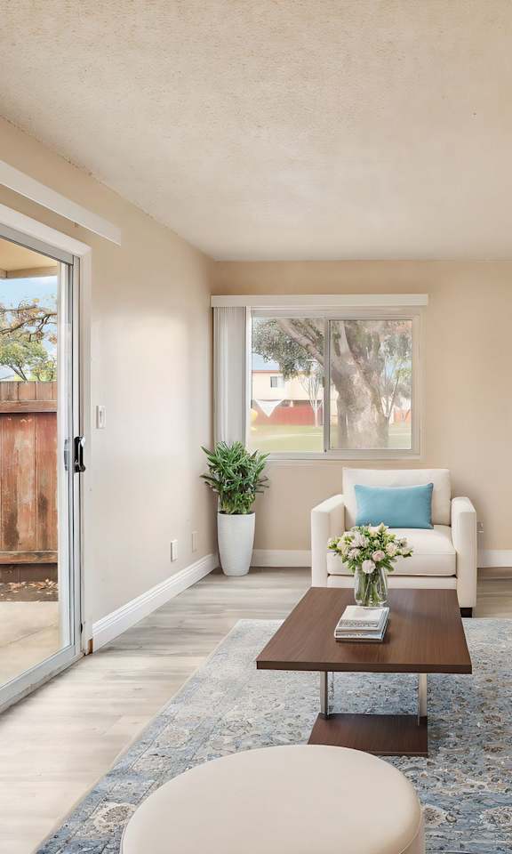 A living room with a white couch, a coffee table, and a painting on the wall.