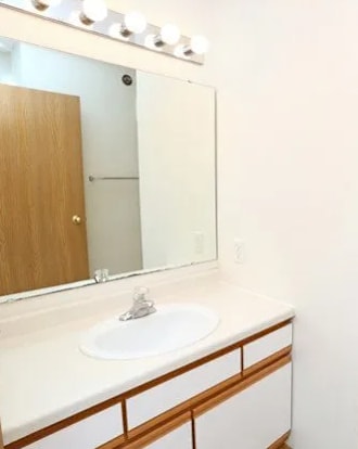 A white toilet sits in a bathroom next to a sink.