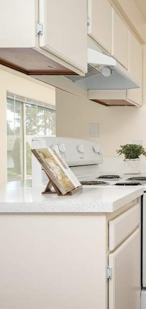 A kitchen with white appliances and a fridge.