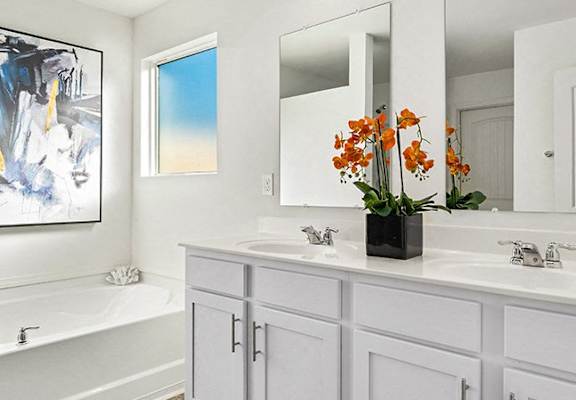 a white bathroom with two sinks and a mirror at The Grove Moundville, Moundville, AL, 35474