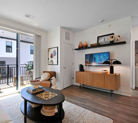 a living room with a door to a balcony and a couch and a table