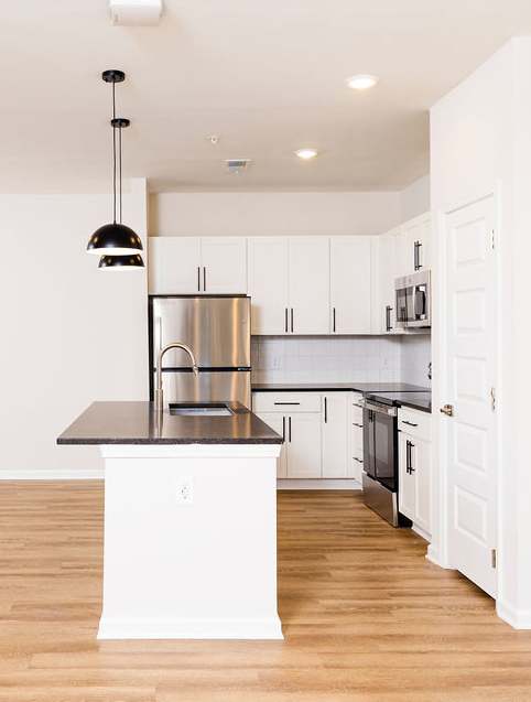a kitchen with a large island and stainless steel appliances at Evolve St. James Apartment Homes Apartments, Southport, NC, 28461