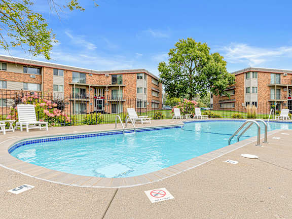 A pool surrounded by apartment buildings with a no swimming sign on the ground.