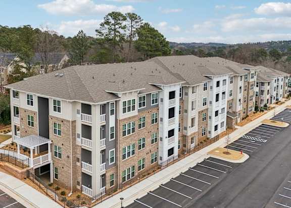 A large apartment complex with a swimming pool in the middle.