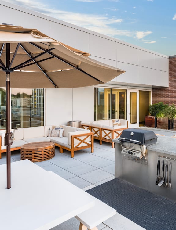 A patio with a grill and seating area.