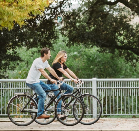 a man and a woman riding bikes on a bridge
