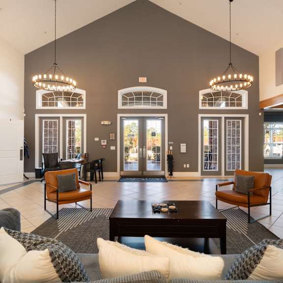 A brick building with a white porch and a black gate. at Stone Gate Apartments, North Carolina, 28390