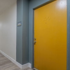 a hallway with a yellow door at the end of it at The Hills Apartments at Thousand Oaks, Thousand Oaks