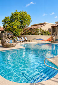 A swimming pool with a slide and sun loungers.