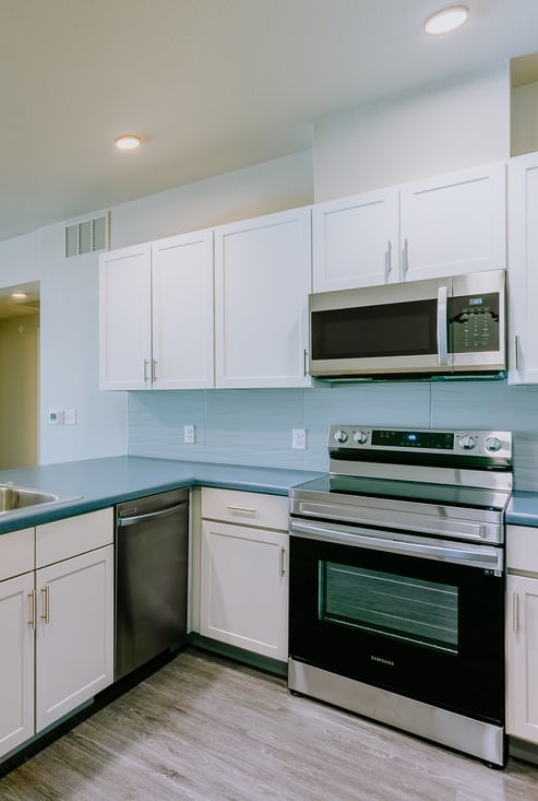 a kitchen with white cabinets and a sink and a stove