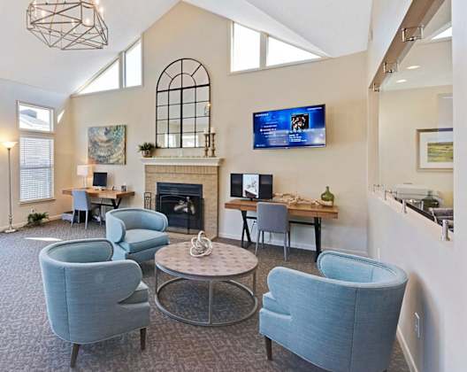 A living room with a fireplace and a TV mounted on the wall. at Fox Hollow Apartment Homes, High Point, NC, 27265