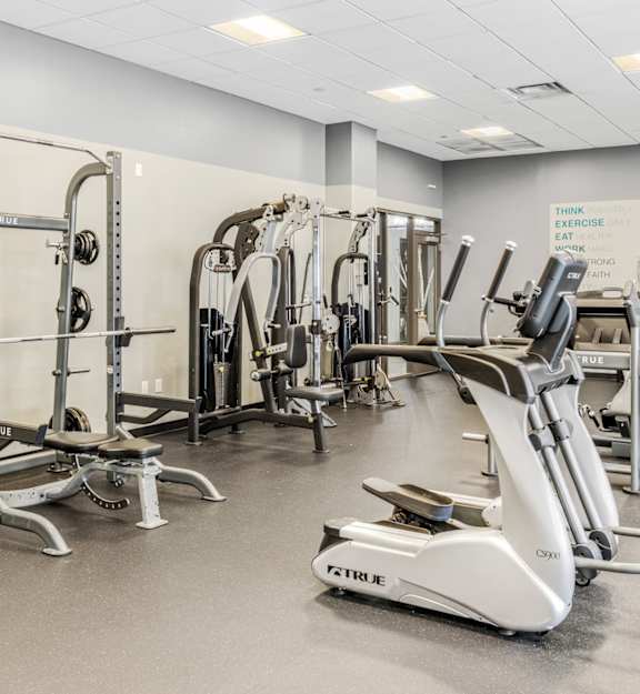 a gym filled with cardio equipment and weights