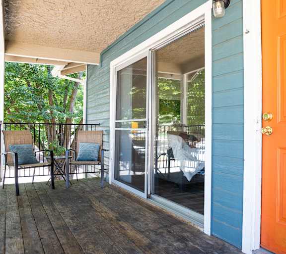 A blue house with a wooden deck and a glass door.at Redwood Cove Apartments, California