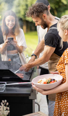 a man and a woman grilling food on a grill