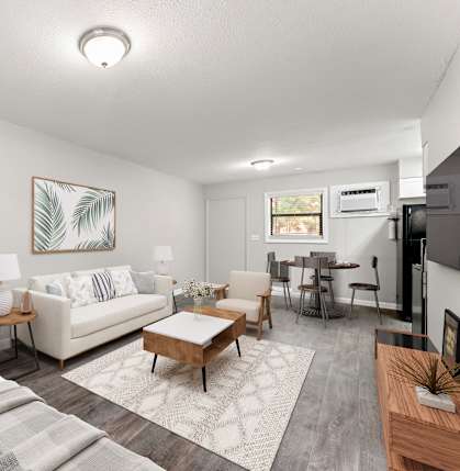 A living room with a couch, chair, and coffee table at Balfour 296 Apartments in Lilburn, GA