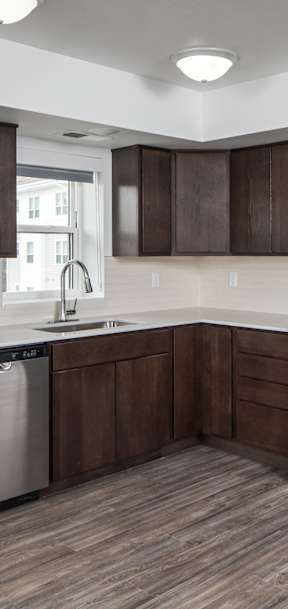 A kitchen with dark brown cabinets and stainless steel appliances.