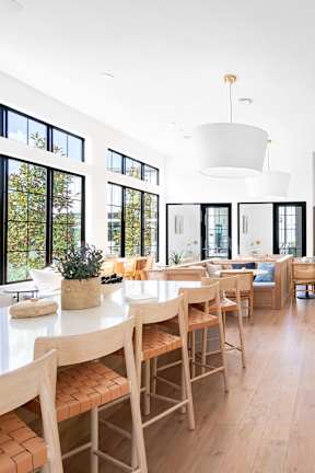 A modern dining room with wooden chairs and a white table.