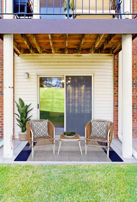 A patio with a table and chairs is surrounded by a brick building.