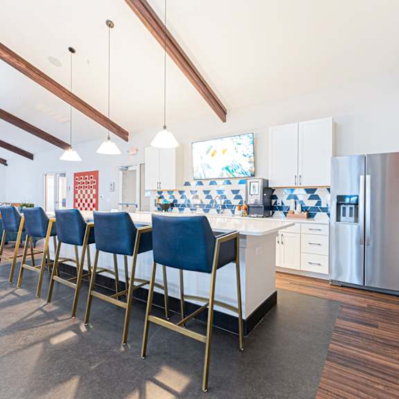 A kitchen with a long table and chairs.