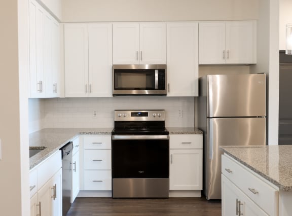 Desiger apartment home kitchen at The Crest at Naples, featuring stainless steel appliances and granite countertops at The Crest at Laurel Canyon Apartments, Naples, Florida