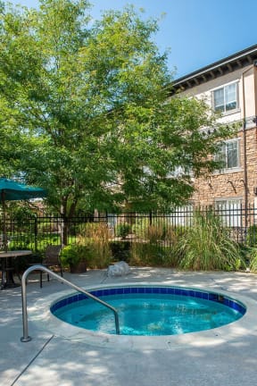 a round swimming pool in front of an apartment building