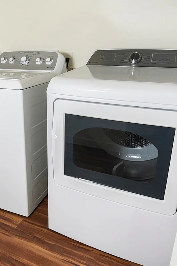 Two white ovens, one with the door open, in a kitchen.