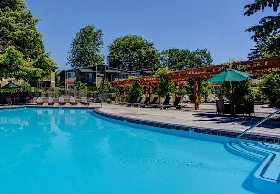 Swimming Pool with Lounge Chairs, at Commons at Timber Creek Apartments in Portland, Oregon
