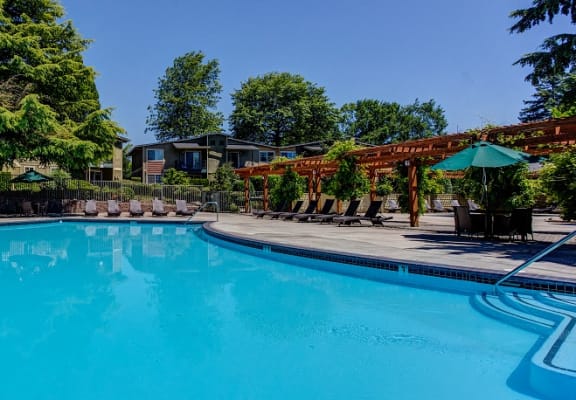 Swimming Pool with Lounge Chairs, at Commons at Timber Creek Apartments in Portland, Oregon