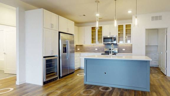 A modern kitchen with a central island and stainless steel appliances.