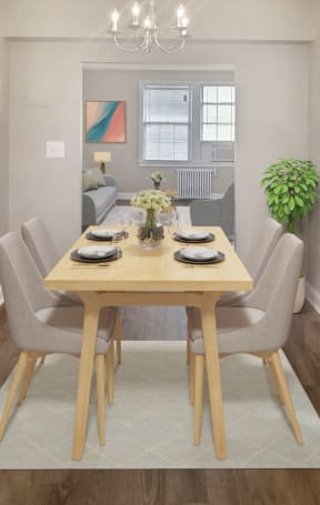 A dining room with a table set for two and a plant on the side table. at Park Crest Apartments, Washington, DC