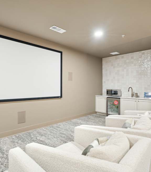 A room with a large screen and multiple chairs.