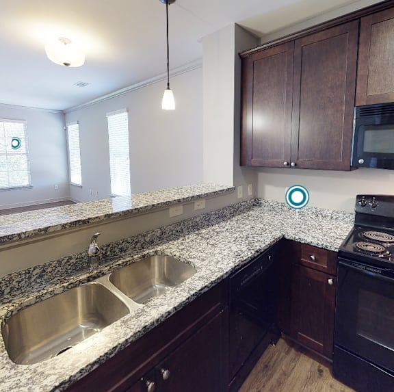 a kitchen with granite counter tops and wooden cabinets at Midtown Row, Montgomery