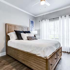 A bedroom with a large bed and a ceiling fan.