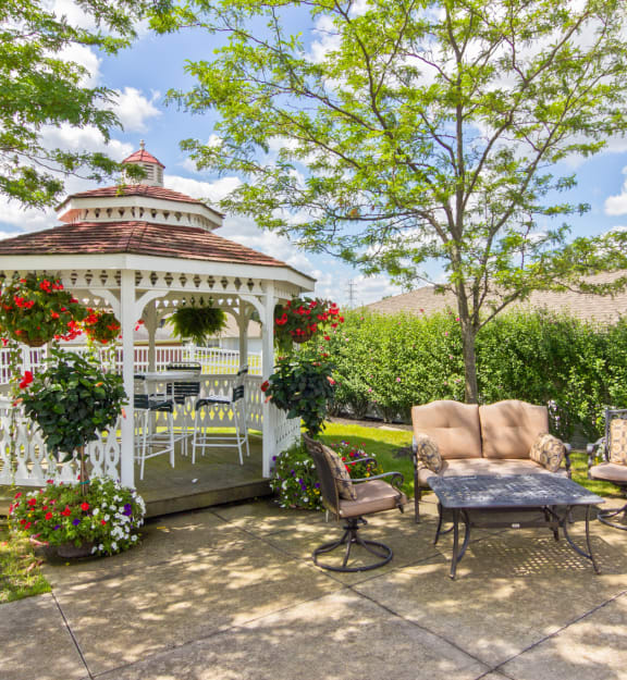 a gazebo on a patio with chairs and a table