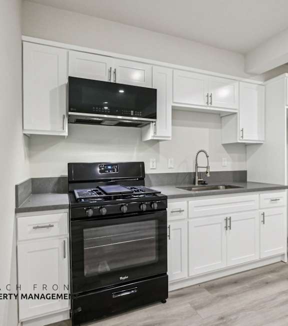 A well-lit, modern kitchen and living room with a dining area.
