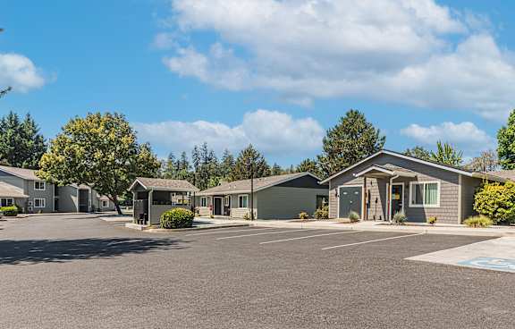 an empty parking lot in front of a row of houses