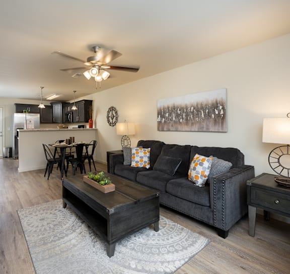 A living room with a grey couch and a wooden coffee table.