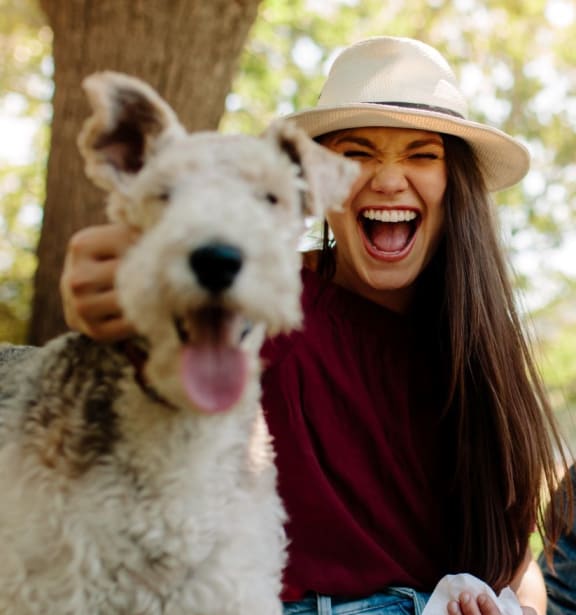 a group of friends sitting in the park with a dog