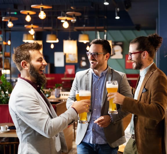 three men drinking beer in a bar