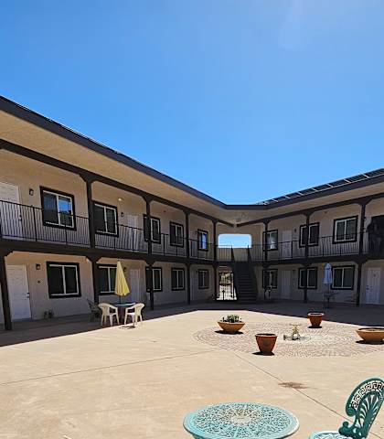 A courtyard with a table and chairs and a dog.