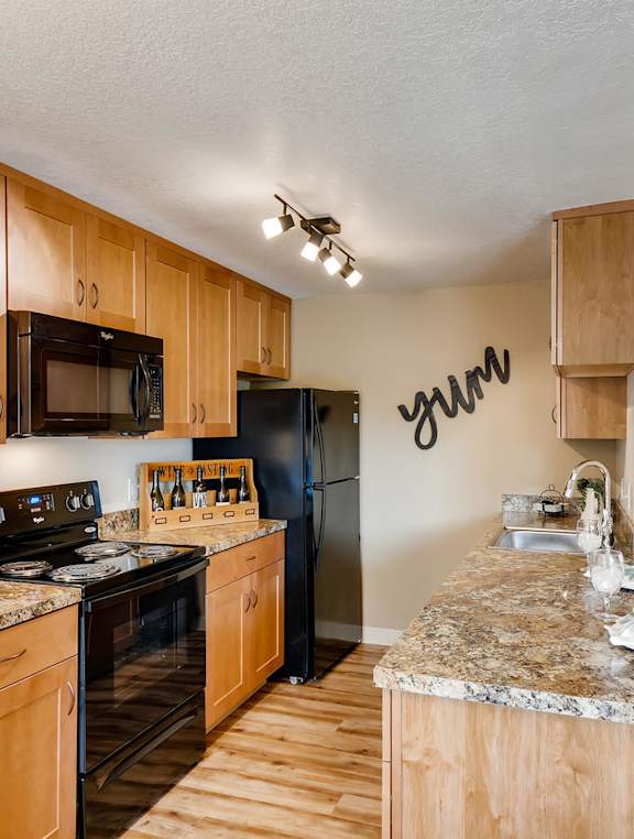 Happy Valley OR Apartments for Rent - Spacious Kitchen with Stylish Interior and Modern Amenities Such as Microwave, Stove, and Refrigerator