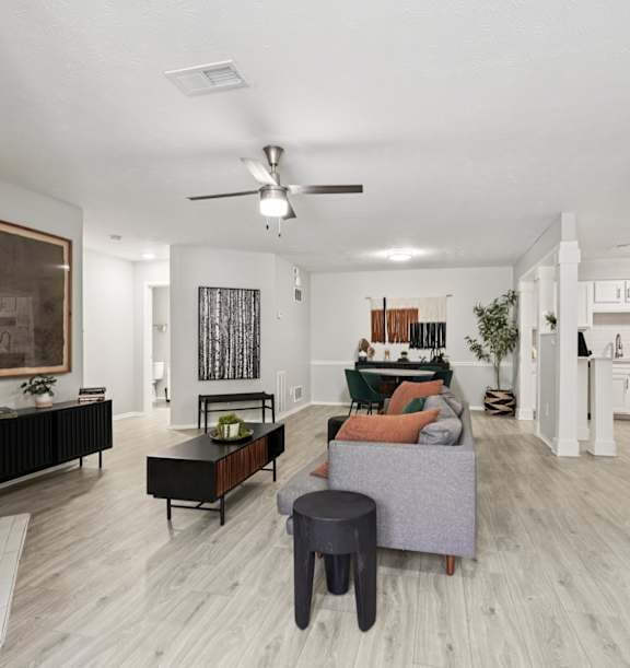 a living room with a white couch and a ceiling fan