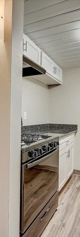 a kitchen with white cabinets and a stove top oven