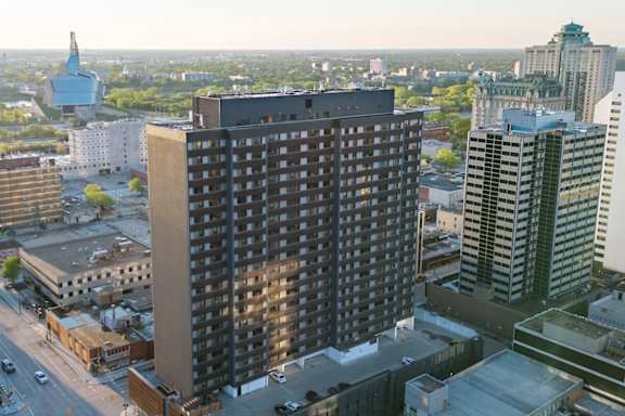 A view from a balcony of a brick building with a playground in the foreground.