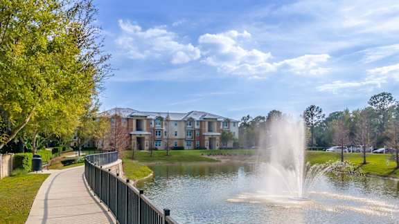 A fountain in the middle of a lake in a park.